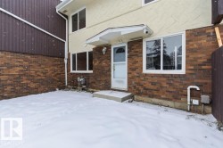 Snow covered property entrance with brick siding - 