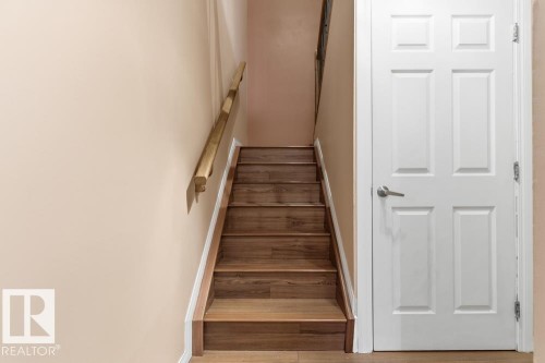 Staircase with baseboards and wood finished floors - 196 Roseland Village, Edmonton, AB - Indoor Photo Showing Other Room