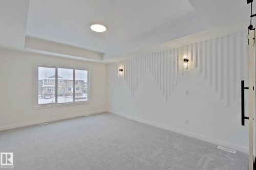 Unfurnished room featuring a raised ceiling and carpet flooring - 3158 Magpie Way, Edmonton, AB - Indoor Photo Showing Other Room