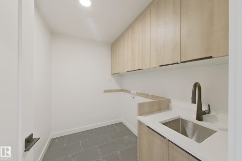 Laundry room featuring washer hookup and cabinet space - 3158 Magpie Way, Edmonton, AB - Indoor