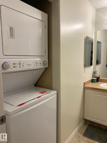 Laundry area with baseboards and stacked washer / dryer - 336 9525 162 Avenue, Edmonton, AB - Indoor Photo Showing Laundry Room
