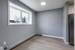 Empty room with baseboard heating, light wood-style floors, and a textured ceiling - 