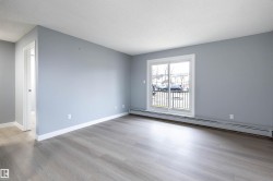 Spare room with a baseboard heating unit, light wood finished floors, and a textured ceiling - 