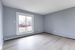 Unfurnished room with light wood-style floors, a textured ceiling, a baseboard radiator, and a baseboard heating unit - 