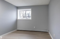 Unfurnished room with a baseboard radiator, light wood-type flooring, and a textured ceiling - 