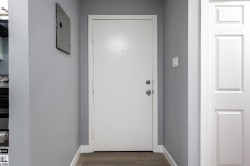 Doorway featuring wood finished floors and electric panel - 
