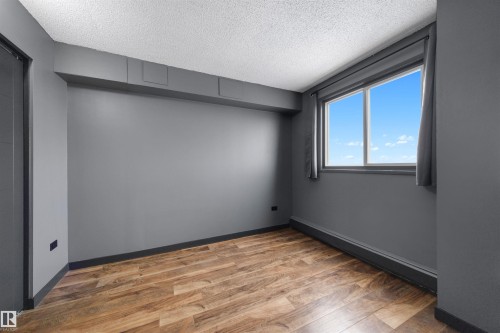 Empty room with wood finished floors and a textured ceiling - 1702 10150 117 Street, Edmonton, AB - Indoor Photo Showing Other Room