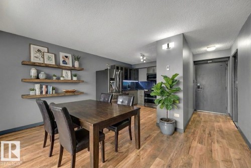 Dining room with a textured ceiling and light wood finished floors - 1702 10150 117 Street, Edmonton, AB - Indoor Photo Showing Dining Room
