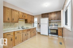 Kitchen with light countertops, stainless steel range with electric stovetop, freestanding refrigerator, a textured ceiling, and light wood finished floors - 