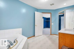 Bathroom with vanity, a garden tub, light floors, and a textured ceiling - 