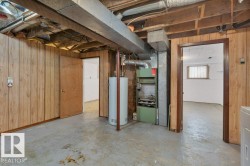 Below grade area with wooden walls, water heater, heating unit, and washer / clothes dryer - 