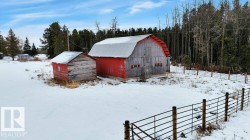 Snow covered structure with a barn and a forest view - 