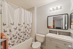 Full bathroom featuring shower / tub combo with curtain and vanity - 