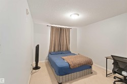 Carpeted bedroom with a textured ceiling and an office area - 