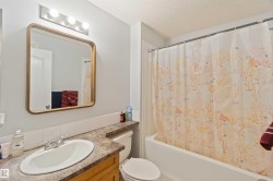 Bathroom featuring vanity, shower / bathtub combination with curtain, and a textured ceiling - 