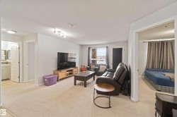 Living area featuring light colored carpet and a textured ceiling - 