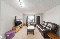 Carpeted living room with a textured ceiling - 
