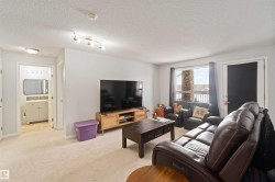 Living room with light colored carpet and a textured ceiling - 