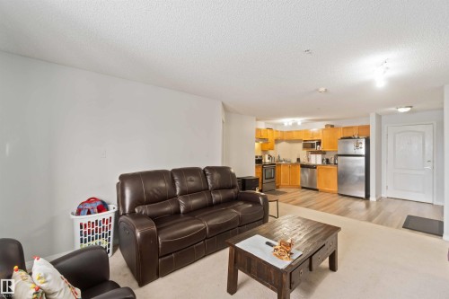 Living area featuring a textured ceiling - 2117 9357 Simpson Drive, Edmonton, AB - Indoor Photo Showing Living Room