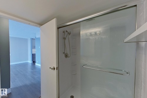 Full bath featuring a stall shower and wood finished floors - 133 8735 165 Street, Edmonton, AB - Indoor Photo Showing Bathroom
