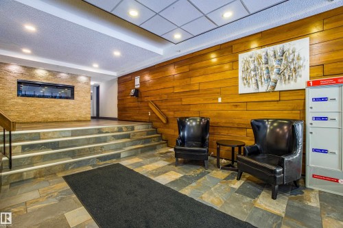 Common area with stairs, wooden walls, recessed lighting, and a textured ceiling - 133 8735 165 Street, Edmonton, AB - Indoor Photo Showing Other Room