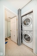 Laundry room featuring stacked washer and clothes dryer and light flooring - 