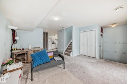 Living area featuring stairway and light colored carpet - 