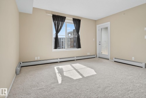 Empty room featuring carpet and baseboard heating - 414 12035 22 Avenue, Edmonton, AB - Indoor Photo Showing Other Room
