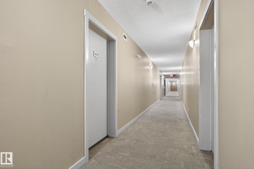 Hallway with light carpet and a textured ceiling - 414 12035 22 Avenue, Edmonton, AB - Indoor Photo Showing Other Room