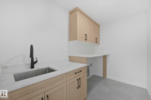 Laundry room featuring cabinet space and light tile patterned floors - 3140 Magpie Wy, Edmonton, AB - Indoor Photo Showing Kitchen