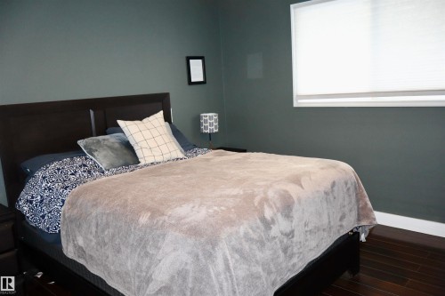 Bedroom with wood finished floors and baseboards - 4505 58 Avenue, Barrhead, AB - Indoor Photo Showing Bedroom