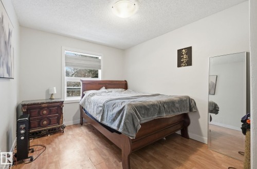 Bedroom featuring light wood-style flooring and a textured ceiling - 9705 87 Avenue, Edmonton, AB - Indoor Photo Showing Bedroom