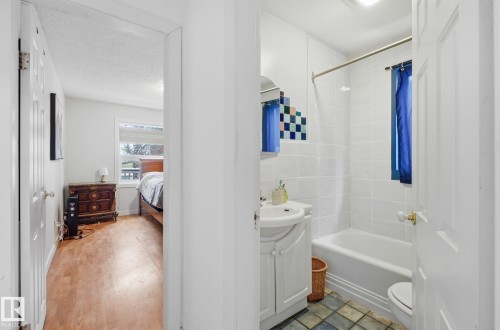 Bathroom with vanity, shower / tub combo with curtain, a textured ceiling, and ensuite bath - 9705 87 Avenue, Edmonton, AB - Indoor Photo Showing Bathroom