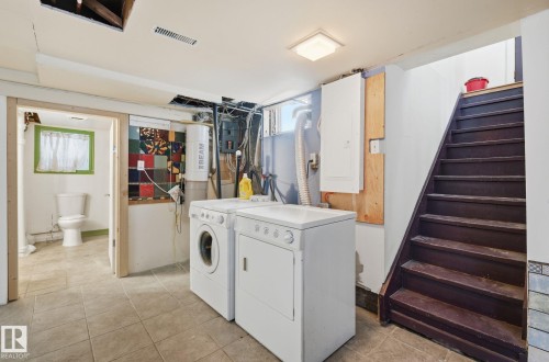 Washroom with electric panel, washing machine and dryer, and light tile patterned floors - 9705 87 Avenue, Edmonton, AB - Indoor Photo Showing Laundry Room
