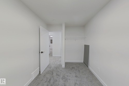 Unfurnished bedroom with light colored carpet and a closet - 65 18120 28 Avenue, Edmonton, AB - Indoor Photo Showing Other Room