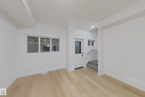 Spare room featuring light wood-style flooring and stairs - 65 18120 28 Avenue, Edmonton, AB - Indoor Photo Showing Other Room