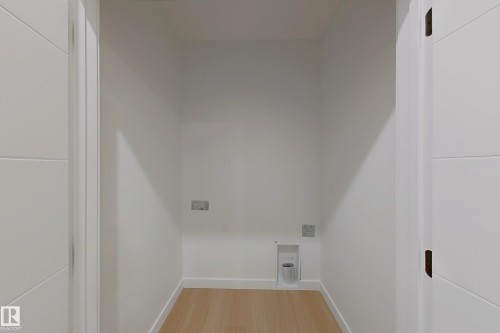 Laundry area with baseboards and light wood-type flooring - 65 18120 28 Avenue, Edmonton, AB - Indoor