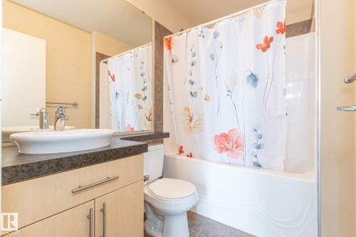 Bathroom featuring shower / bath combo with shower curtain, vanity, and tile patterned floors - 904 10136 104 Street Nw, Edmonton, AB - Indoor Photo Showing Bathroom