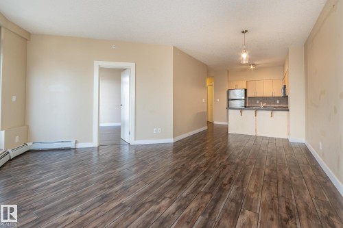 Unfurnished living room featuring dark wood finished floors and a textured ceiling - 904 10136 104 Street Nw, Edmonton, AB - Indoor Photo Showing Kitchen