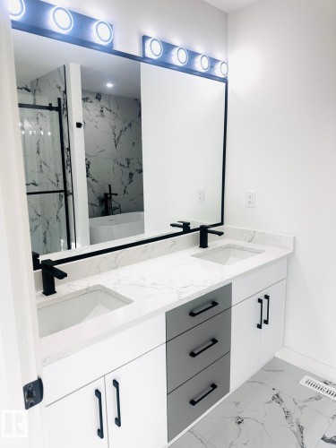 Full bathroom featuring light marble finish flooring, a soaking tub, double vanity, and a marble finish shower - 3906 41 Avenue, Beaumont, AB - Indoor Photo Showing Bathroom