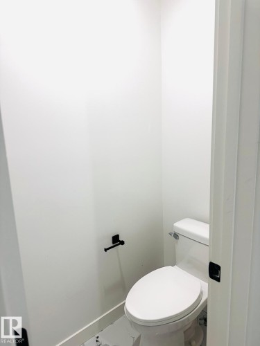 Bathroom featuring toilet and baseboards - 3906 41 Avenue, Beaumont, AB - Indoor Photo Showing Bathroom