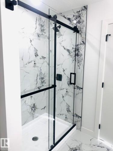 Full bath featuring a marble finish shower and marble finish flooring - 3906 41 Avenue, Beaumont, AB - 