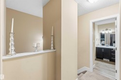 Hall featuring a textured ceiling and light carpet - 