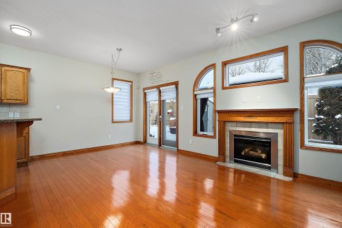 Unfurnished living room featuring light wood-type flooring, a fireplace, a textured ceiling, and healthy amount of natural light - 4931 48 Avenue, Onoway, AB - Indoor Photo Showing Living Room With Fireplace