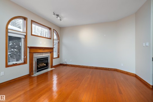 Unfurnished living room featuring a tile fireplace, light wood-type flooring, and track lighting - 4931 48 Avenue, Onoway, AB - Indoor Photo Showing Other Room With Fireplace