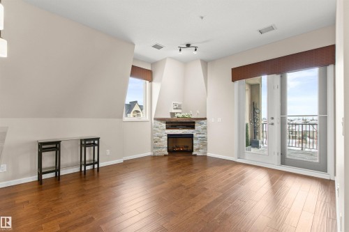425 6083 Maynard Way E, Edmonton, AB - Indoor Photo Showing Living Room With Fireplace