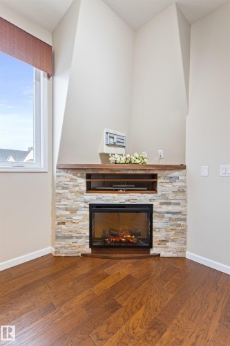 425 6083 Maynard Way E, Edmonton, AB - Indoor Photo Showing Living Room With Fireplace