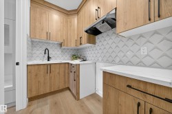 Laundry area with light wood-style flooring and a sink - 