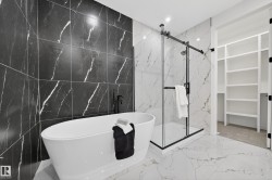 Full bath featuring light marble finish flooring, a soaking tub, a marble finish shower, recessed lighting, and stone wall - 