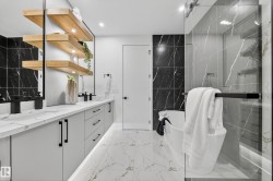 Bathroom featuring double vanity, a freestanding tub, light marble finish flooring, a marble finish shower, and recessed lighting - 